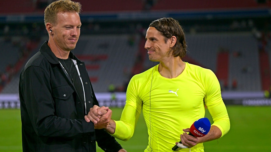 Bayern-Coach Julian Nagelsmann (l.) und Gladbach-Keeper Yann Sommer (r.) am 27. August 2022 im Interview mit „Sky“ beim freundschaftlichen Hand-Shake. Nagelsmann ist schwarz gekleidet, Sommer trägt ein neongelbes Sportshirt von Puma. Beide grinsen.
