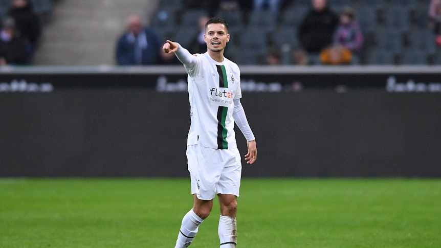 Julian Weigl von Borussia Mönchengladbach gibt seinen Mitspielern Anweisungen und macht mit dem rechten Zeigefinger eine Geste. Weigl trägt das weiße Gladbach-Heimtrikot im Testspiel gegen den FC St. Pauli am 14. Januar 2023.