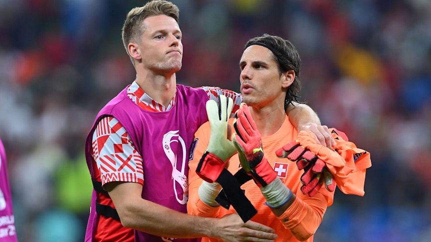 Die beiden Schweizer Nationaltorhüter Jonas Omlin (l.) und Yann Sommer (r.), hier zu sehen am 6. Dezember 2022 während der Fußball-Weltmeisterschaft in Katar. Omlin umarmt einen enttäuschten Sommer nach dem WM-Aus gegen Portugal.