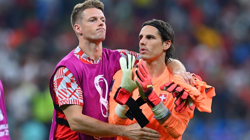 Die beiden Schweizer Nationaltorhüter Jonas Omlin (l.) und Yann Sommer (r.), hier zu sehen am 6. Dezember 2022 während der Fußball-Weltmeisterschaft in Katar. Omlin umarmt einen enttäuschten Sommer nach dem WM-Aus gegen Portugal.