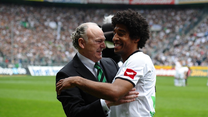 Dante (r.) umarmt Rolf Königs, Präsident von Borussia Mönchengladbach, bei seiner Verabschiedung am 28. April 2012. Dante trägt das weiße Heimtrikot von Gladbach, Königs einen Anzug.
