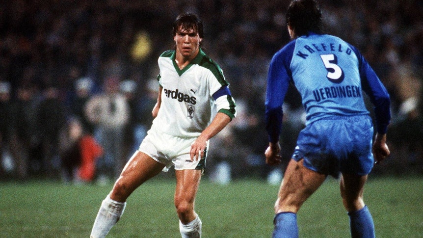 Lothar Matthäus spielt den Ball in der Bundesliga-Partie gegen Bayer Uerdingen am 25. November 1983 und trägt ein weißes Trikot von Borussia Mönchengladbach.