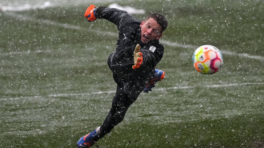 Jonas Omlin, Torhüter von Borussia Mönchengladbach, fliegt am 20. Januar 2023 beim Training im Schneetreiben einem Ball hinterher.