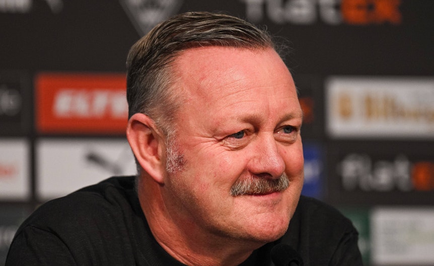 Roland Virkus ist Sportdirektor bei Fußball-Bundesligist Borussia Mönchengladbach. Auf diesem Foto ist er am 20. Januar 2023 während einer Pressekonferenz im Borussia-Park zu sehen. Virkus lächelt im Presseraum, er trägt einen dunken Pulli.