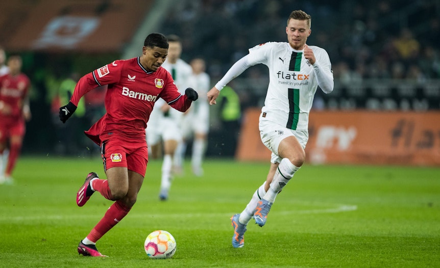 Gladbach-Verteidiger Nico Elvedi (r.) kommt nicht mit, Leverkusen-Flitzer Amine Adli ist auf dem Weg zum Torerfolg im Bundesliga-Duell am Sonntag (22. Januar 2023) im Borussia-Park.