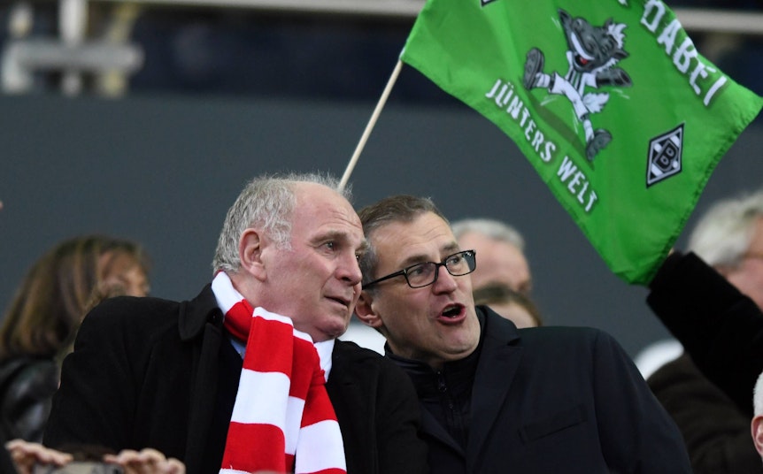 Bayern-München-Macher Uli Hoeneß (I.) beim Spiel seines FC Bayern bei Borussia Mönchengladbach im Borussia-Park am 2. März 2019. Hoeneß trägt einen rot-weißen Schal. Im Hintergrund ist eine Gladbach-Fahne zu sehen.