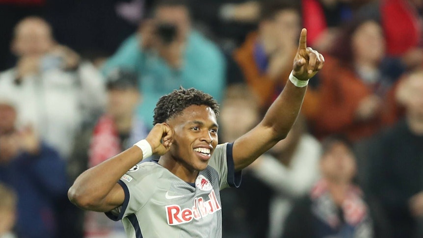 Junior Adamu bejubelt einen Treffer im Champions-League-Spiel von Red Bull Salzburg gegen den FC Chelsea am 25. Oktober 2022. Adamu fasst sich mit der rechten Hand an das rechte Ohr und zeigt mit seinem linken Zeigefinger in die Luft.