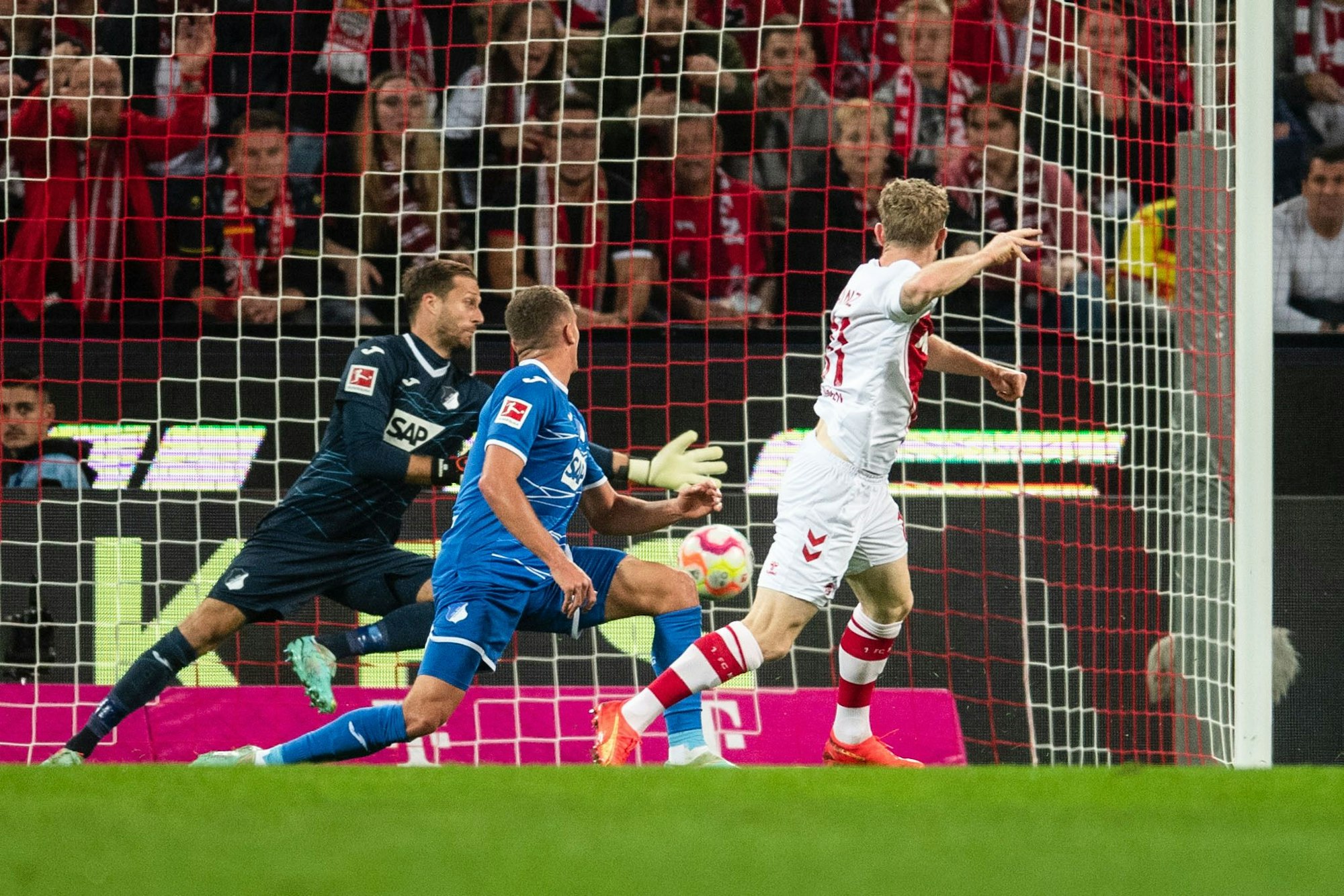 Kölns Florian Kainz (r) trifft gegen Hoffenheims Torhüter Oliver Baumann (l) und Grischa Prömel zur 1:0-Führung.