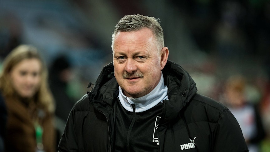 Roland Virkus steht am Spielfeldrand der WWK-Arena in Augsburg im Rahmen des Bundesliga-Spiels FC Augsburg gegen Borussia Mönchengladbach am 25. Januar 2023. Der Sportdirektor von Borussia Mönchengladbach trägt eine Winterjacke von Gladbach-Ausrüster Puma.