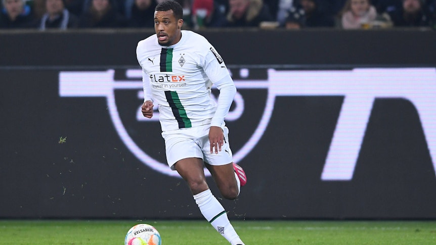 Alassane Plea läuft mit dem Ball am Fuß über den Rasen im Borussia Park. Aufgenommen wurde das Foto am 22. Januar 2023 beim Bundesliga-Spiel von Borussia Mönchengladbach gegen Bayer Leverkusen, Plea trägt das weiße Gladbach-Heimtrikot.