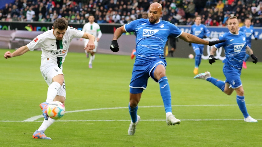 Nicht zu stoppen! Gladbach-Star und DFB-Nationalspieler Jonas Hofmann (l.) trifft in dieser Szene für Borussia Mönchengladbach beim 4:1-Sieg (28. Januar 2023) bei der TSG Hoffenheim. Hofmann zieht mit dem rechten Fuß ab, Brooks kann ihn nicht hindern.