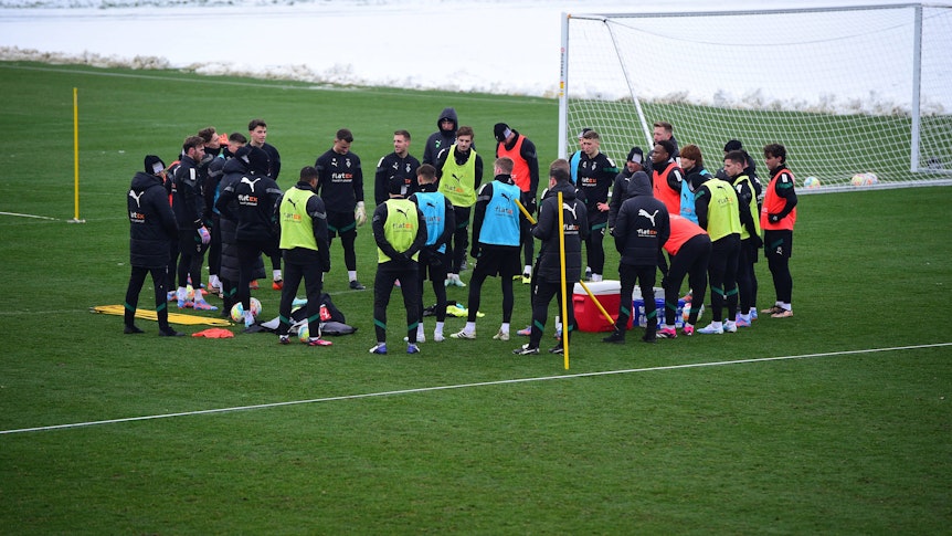 Das Team von Borussia Mönchengladbach hier bei einer Trainingseinheit am 19. Januar 2023 im Kreis stehend in bunten Leibchen.