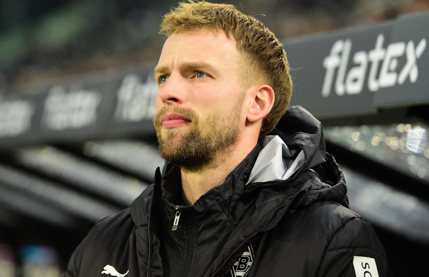 Gladbach-Verteidiger Marvin Friedrich, hier zu sehen am 22. Januar 2023 im Borussia-Park. Friedrich trägt Trainingskluft und blickt von der Bank Richtung Spielfeld.