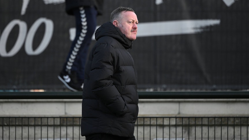 Roland Virkus geht am 7. Januar 2023 am Spielfeldrand des Fohlenplatz von Borussia Mönchengladbach entlang. Der Sportdirektor von Borussia Mönchengladbach trägt eine schwarze Winterjacke.