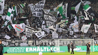 Die Gladbach-Fans in der Nordkurve unterstützen die Borussia bei einem Heimspiel. Dieses Foto aus dem Borussia-Park stammt vom 4. Februar 2023. Zu sehen sind Fahnen und Schals von Hunderten Fohlen-Anhängern.