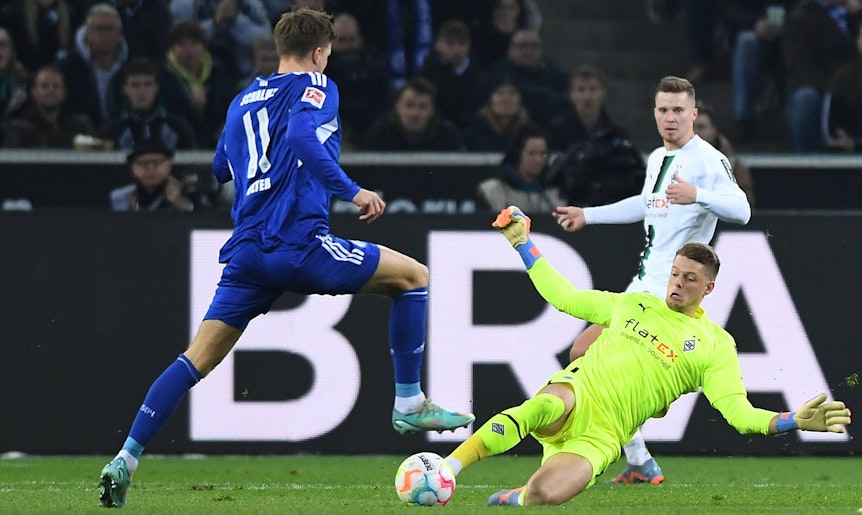 Voller Körpereinsatz. Gladbach-Torwart Jonas Omlin (r.) klärt am 4. Februar 2023 per Grätsche vor Schalke-Stürmer Marius Bülter. Im Hintergrund schaut Nico Elvedi zu.