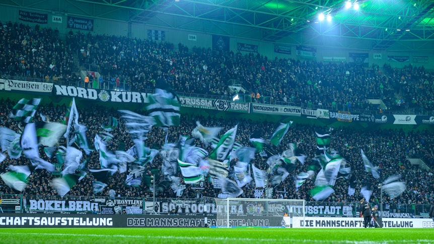 In dieser Saison gut besucht: Der Borussia-Park, die Heimspielstätte von Bundesligist Borussia Mönchengladbach. Das Foto zeigt Fahnen schwenkende Fans in der Nordkurve am 22. Januar 2023 beim Spiel gegen Bayer 04 Leverkusen.