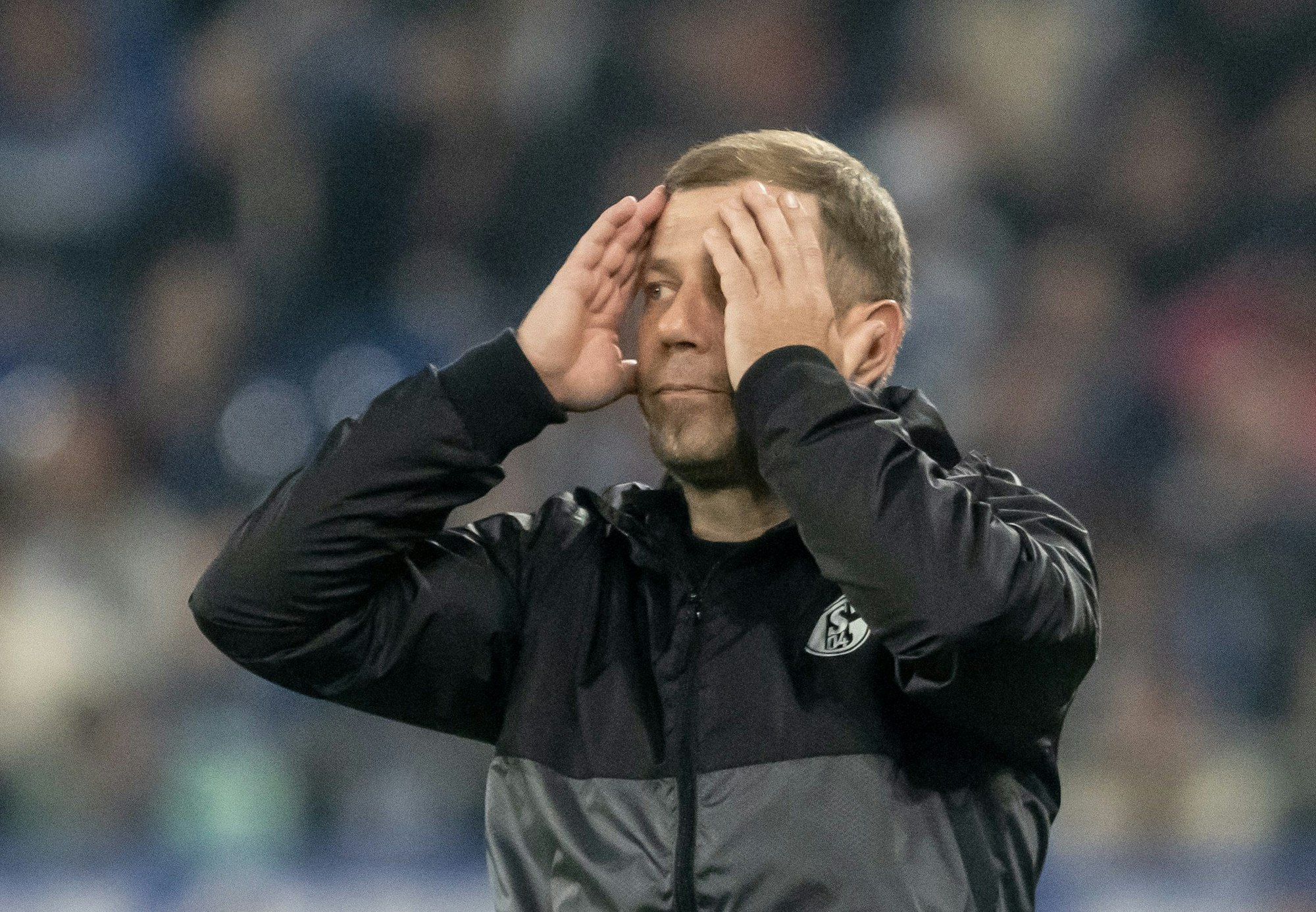 Trainer Frank Kramer von Schalke fasst sich bei einem Spiel seiner Mannschaft den Kopf.