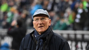 Wolfgang Kleff steht am 20. November 2021 im Rahmen eines Bundesliga-Spiels von Borussia Mönchengladbach gegen Greuther Fürth am Spielfeldrand im Borussia-Park. Der ehemalige Gladbach-Torwart trägt eine dunkle Jacke und eine Kappe.