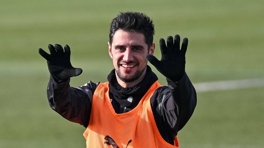 Lars Stindl streckt im Training von Borussia Mönchengladbach beide Arme nach vorne und lächelt. Der Gladbach-Kapitän trägt bei der Einheit auf dem Trainingsplatz im Borussia-Park am 9. Februar 2023 dunkle Trainingskleidung und ein Leibchen.