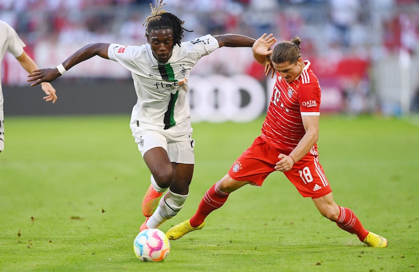Gladbach-Juwel Manu Koné (l.) im Bundesliga-Duell (27. August 2022) mit Bayern-München-Star Marcel Sabitzer (r.) in der Allianz-Arena. Vor dem Rückspiel am Samstag (18. Februar 2023) spricht Koné exklusiv über seine Karriere-Ziele im GladbachLIVE-Interview.