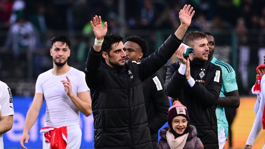 Lars Stindl, Kapitän von Borussia Mönchengladbach, reißt beide Arme in die Luft, um die Gladbach-Fan auf der Tribüne nach dem Sieg gegen den FC Bayern München am 18. Februar 2023 zu grüßen. Um ihn herum stehen die Mitspieler Ramy Bensebaini, Nathan Ngoumou, Christoph Kramer und Marcus Thuram (v.l.n.r).
