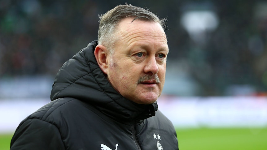 Sportdirektor Roland Virkus von Borussia Mönchengladbach vor dem Bundesliga-Spiel gegen den FC Bayern München am 18. Februar 2023. Virkus trägt eine schwarze Winterjacke mit dem Logo von Borussia Mönchengladbach und Puma.