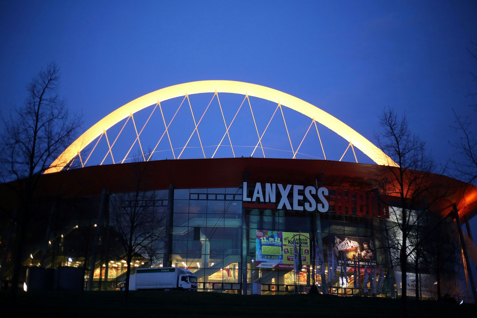 Die Lanxess Arena in Köln beleuchtet bei Nacht. 