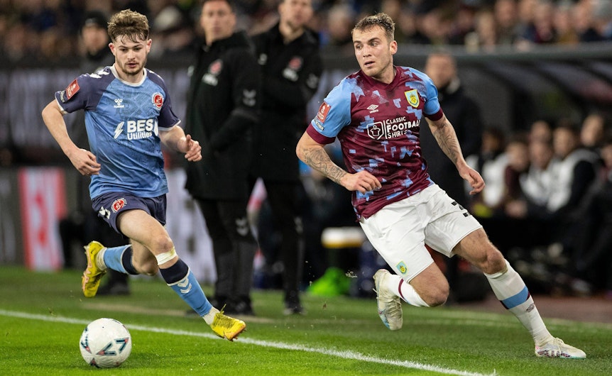 Gladbach hat Jordan Beyer (r.) an England-Klub FC Burnley verliehen. Auf diesem Foto ist der Verteidiger im Einsatz (1. März 2023) gegen Fleetwood Town zu sehen. Beyer hat den Ball im vollen Lauf im Blick, sein Gegenspieler läuft hinterher.