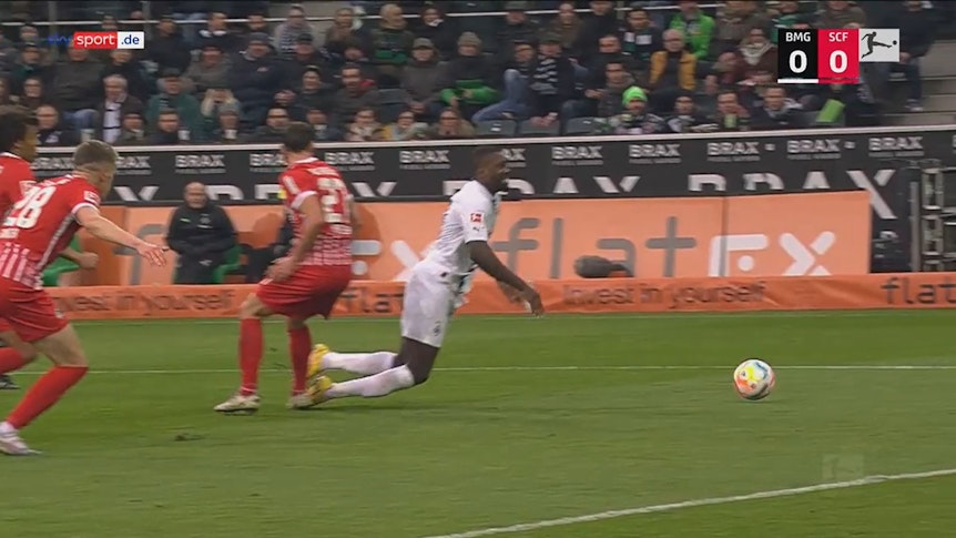 Marcus Thuram geht im Spiel zwischen Borussia Mönchengladbach und dem SC Freiburg zu Boden.