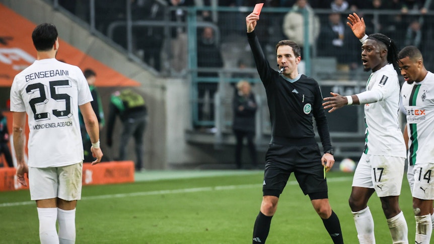 Benjamin Brand (Mitte) zeigte Gladbach-Profi Ramy Bensebaini (l.) am Samstag (4. März 2023) in der Schlussphase der Partie gegen den SC Freiburg die Gelb-Rote Karte. Der Algerier reagierte mit verbalen Entgleisungen auf die Entscheidung.