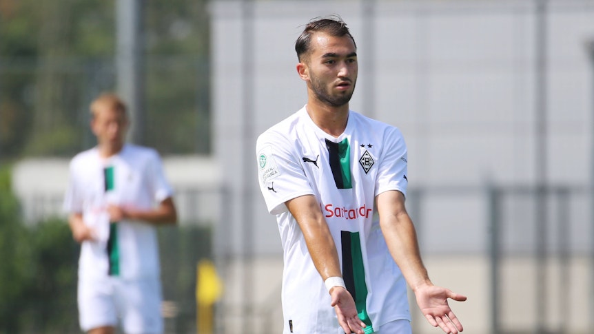 Daniel Aserov, Spieler der U17 von Borussia Mönchengladbach, hier am 20. August 2022 beim B-Junioren-Bundesligaspiel gegen Preußen Münster. Aserov hat beide Hände nach flach nach vorne ausgebreitet und zeigt an, angespielt werden zu wollen.