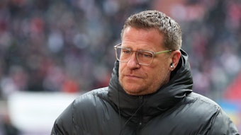 Max Eberl ist nach seinem Abschied von Borussia Mönchengladbach im Januar 2022 seit 101 Tagen bei RB Leipzig tätig. Das Foto zeigt Eberl beim ersten Aufeinandertreffen mit seinem Ex-Verein Gladbach am 11. März 2023. Eberl steht in einer Winterjacke am Spielfeldrand und blickt nach unten.