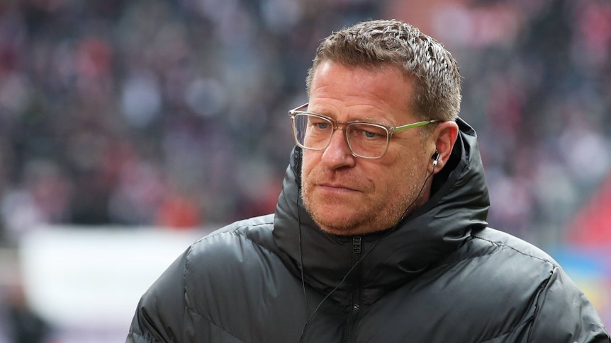 Max Eberl ist nach seinem Abschied von Borussia Mönchengladbach im Januar 2022 seit 101 Tagen bei RB Leipzig tätig. Das Foto zeigt Eberl beim ersten Aufeinandertreffen mit seinem Ex-Verein Gladbach am 11. März 2023. Eberl steht in einer Winterjacke am Spielfeldrand und blickt nach unten.