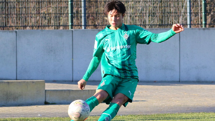 Shio Fukuda, hier am 14. Februar 2023, läuft seit Anfang Februar 2023 für Borussia Mönchengladbach auf und kommt aktuell für die U19 zum Einsatz. Auf dem Foto tritt der Angreifer aus Japan eine Ecke im grünen Auswärts-Trikot von Gladbach.