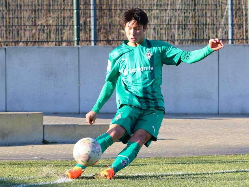 Shio Fukuda, hier am 14. Februar 2023, läuft seit Anfang Februar 2023 für Borussia Mönchengladbach auf und kommt aktuell für die U19 zum Einsatz. Auf dem Foto tritt der Angreifer aus Japan eine Ecke im grünen Auswärts-Trikot von Gladbach.