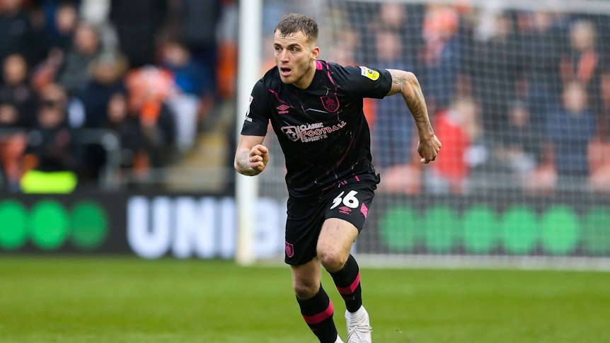 Jordan Beyer, hier am 4. März 2023, läuft im dunklen Auswärtstrikot des FC Burnley mit dem Ball nach vorne. Das Foto zeigt Beyer im Spiel gegen Blackpool in der englischen Championship.