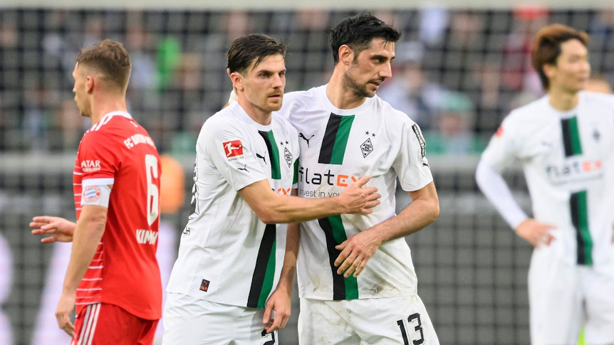 DFB-Nationalspieler Jonas Hofmann (2.v.l.) jubelt nach dem Bundesliga-Triumph von Borussia Mönchengladbach gegen Bayern München am 18. Februar 2023 im Borussia-Park gemeinsam mit Fohlen-Kapitän Lars Stindl (r.). Die beiden Gladbach-Spieler liegen sich nach Abpfiff im Borussia-Park in den Armen.