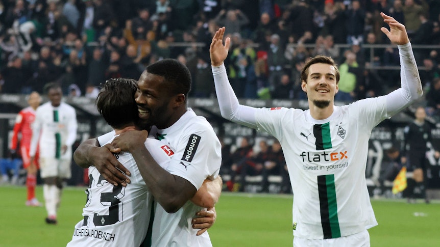 Jonas Hofmann und Marcus Thuram liegen sich nach einem Tor im Bundesliga-Spiel von Borussia Mönchengladbach gegen Bayern München am 18. Februar 2023 in den Armen. Florian Neuhaus feiert mit.