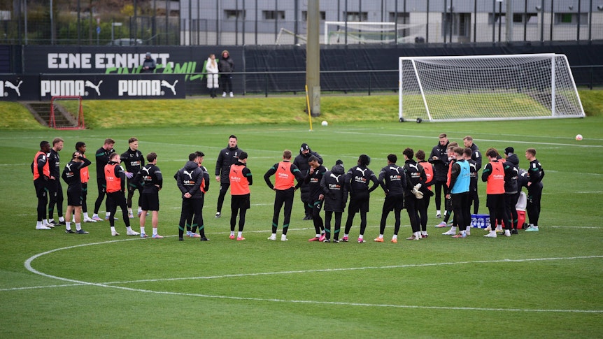 Die Mannschaft von Borussia Mönchengladbach am 14. März 2023 beim Training im Borussia-Park. Das Team steht in einem Kreis zusammen auf dem Rasen.