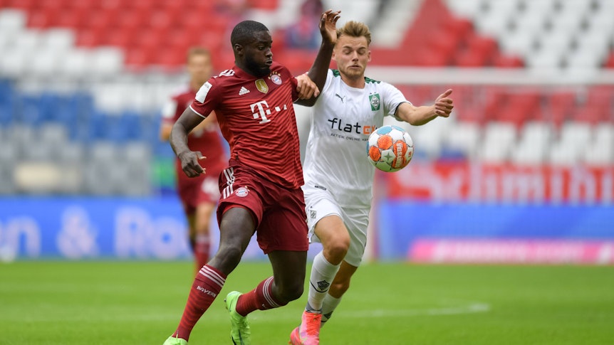 Mika Schroers (r.) liefert sich am 28. Juli 2021 beim Testspiel von Borussia Mönchengladbach bei Bayern München einen Zweikampf mit Dayot Upamecano. Das Foto zeigt die beiden im Kampf um den Ball in der Allianz-Arena.