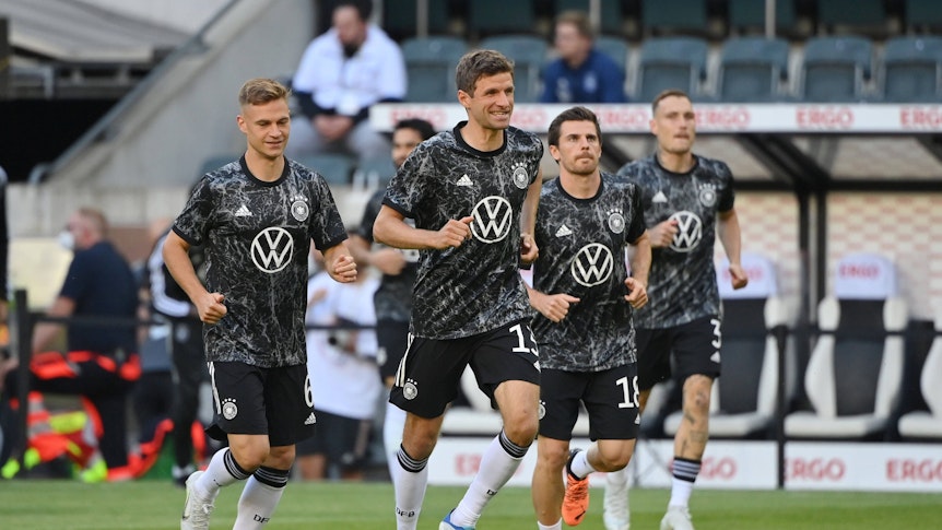 Joshua Kimmich (l.), Thomas Müller (2.v.l.) und Jonas Hofmann (2.v.r.) sind drei der fünf Bundesliga-Rekordhalter beim Kreieren von Großchancen. Das Foto zeigt das Trio vor einem DFB-Länderspiel gegen Italien am 14. Juni 2022, das im Borussia-Park stattfand. Alle tragen ein dunklen Aufwärm-Shirt der deutschen Nationalmannschaft.