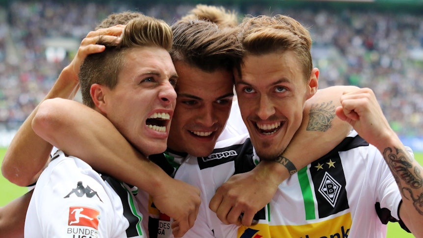 Granit Xhaka (M.) bejubelt einen Treffer im Bundesliga-Spiel von Borussia Mönchengladbach gegen Bayer Leverkusen am 9. Mai 2015 gemeinsam mit seinen damaligen Teamkollegen Patrick Herrmann (l.) und Max Kruse. Xhaka legt dabei seine Arme um Herrmann und Kruse.
