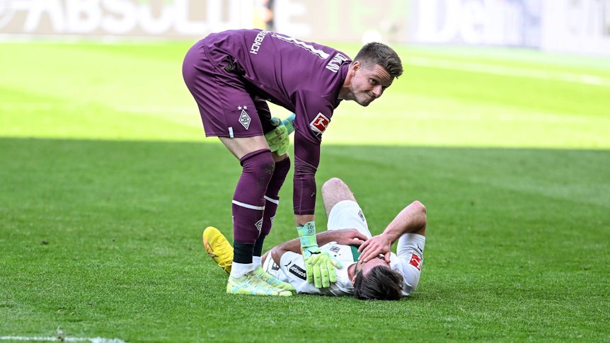 Joe Scally liegt im Bundesliga-Spiel von Borussia Mönchengladbach gegen den VfL Wolfsburg am 9. April 2023 am Boden. Jonas Omlin sorgt sich um den Gladbach-Verteidiger.