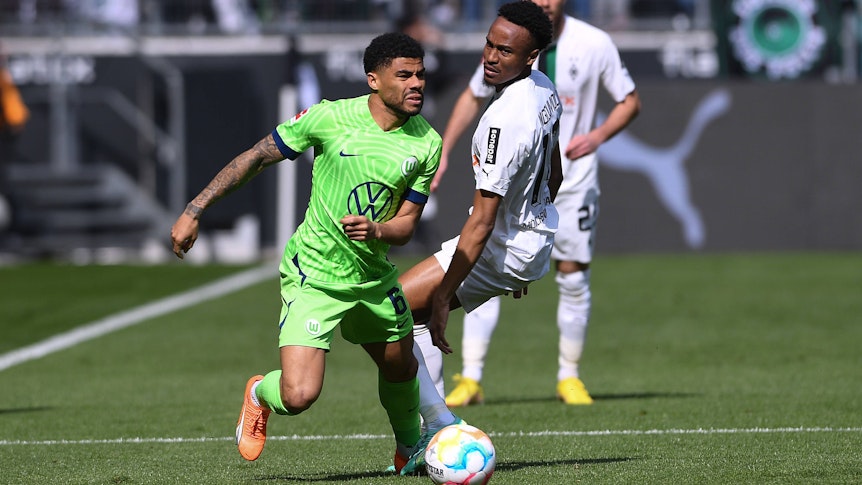Nathan Ngoumou liefert sich im Spiel von Borussia Mönchengladbach gegen den VfL Wolfsburg am 9. April 2023 einen Zweikampf mit Paulo Otavio (l.).