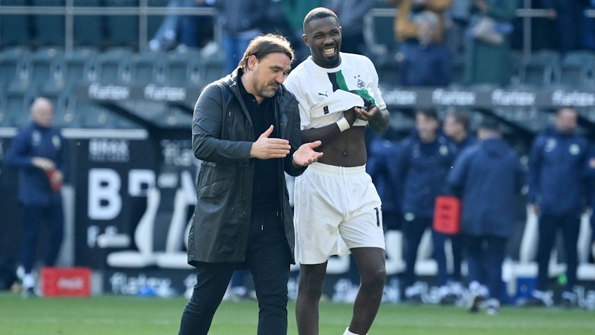 Daniel Farke (l.) spricht nach dem 2:0-Sieg von Borussia Mönchengladbach gegen den VfL Wolfsburg am 9. April 2023 mit Angreifer Marcus Thuram.