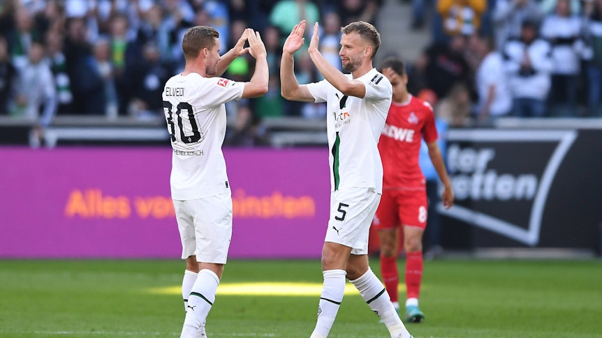 Nico Elvedi (l.) und Marvin Friedrich klatschen sich ab. Das Foto stammt vom Bundesligaspiel Borussia Mönchengladbach gegen den 1. FC Köln am 9. Oktober 2022.