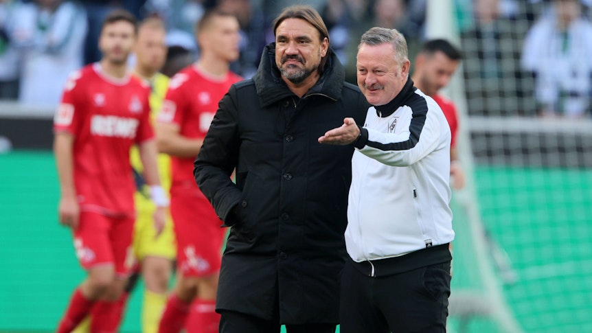Roland Virkus (r.) steht gemeinsam mit Daniel Farke auf dem Rasen im Borussia-Park. Das Foto zeigt die beiden Gladbach-Verantwortlichen nach dem Bundesliga-Spiel gegen den 1. FC Köln am 9. Oktober 2022.