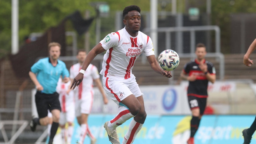 Das Foto zeigt Noel Futeku am 8. Mai 2021 im Regionalliga-Spiel des 1. FC Köln gegen den FC Wegberg-Beeck. Der Angreifer schaut energisch auf den Ball.