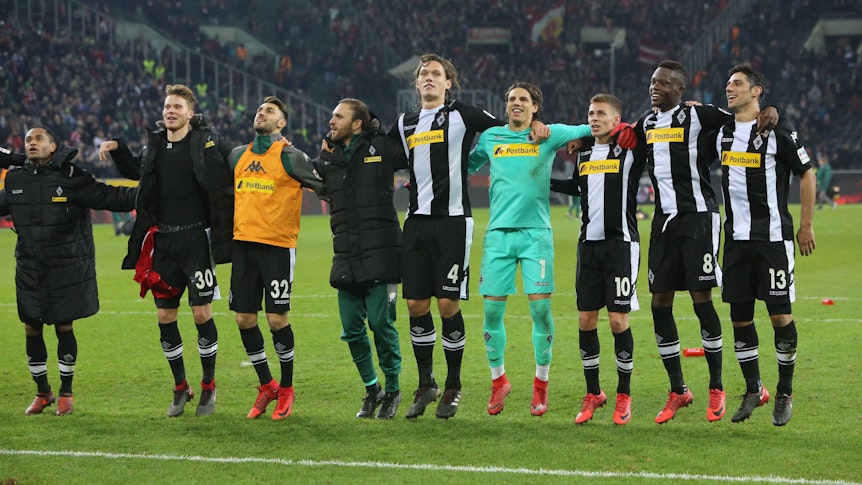 Die Spieler von Borussia Mönchengladbach feiern einen Bundesliga-Sieg gegen Bayern München am 25. November 2017 vor der Nordkurve auf dem Rasen im Borussia-Park und springen in die Luft.
